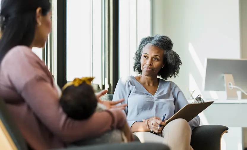 In this image, a therapist begins the case management process as she listens to a client.