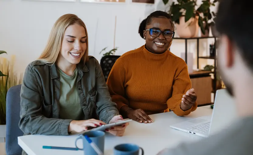 Three millennial coworkers collaborate together at work. Recruiting millennials with corporate philanthropy is simple with the tips in this guide.