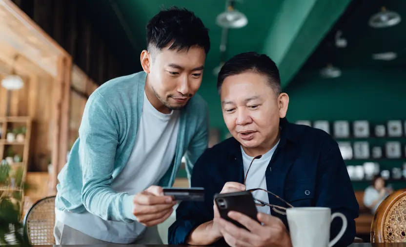 A man helps his father make a donation on his phone using one of these four types of mobile giving.