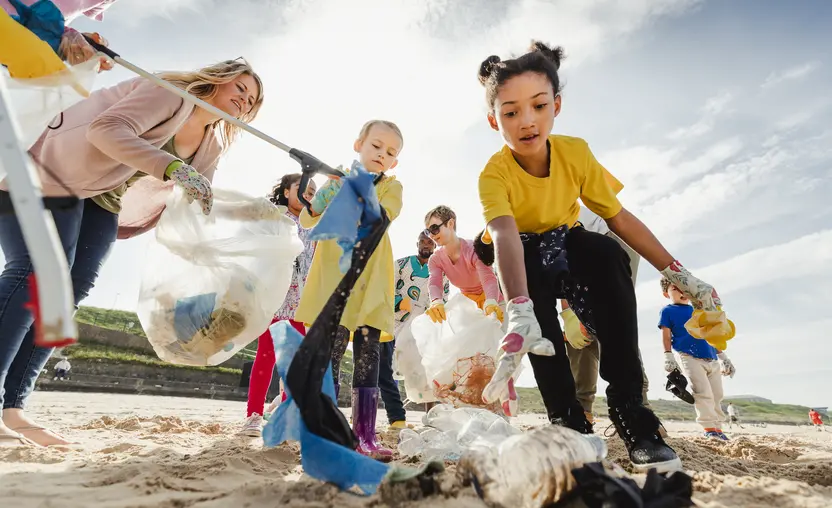 Group of kids and adults all coming together to clean up their local beach.