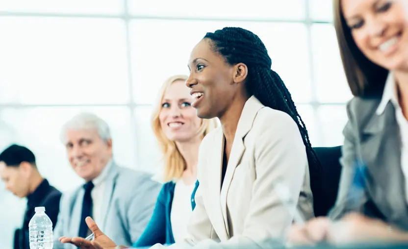 Black professional woman sitting at table with other professionals