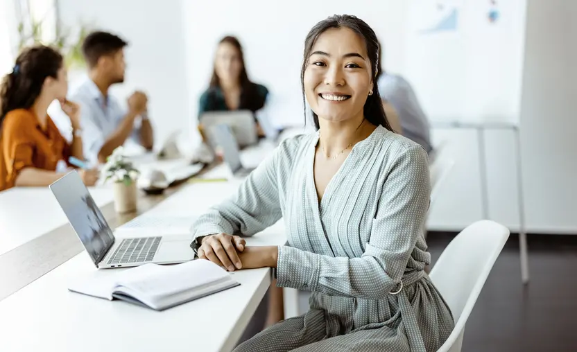 ASian woman sitting at laptop computer in business setting