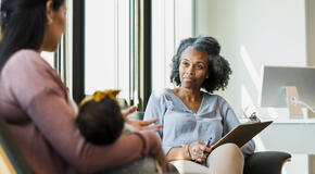 In this image, a therapist begins the case management process as she listens to a client.