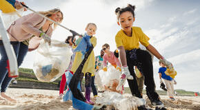 Group of kids and adults all coming together to clean up their local beach.