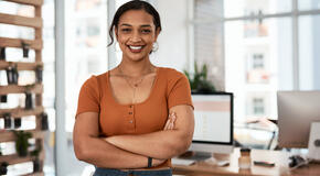 Portrait of an attractive and confident young businesswoman posing with her arms folded inside an office. 
