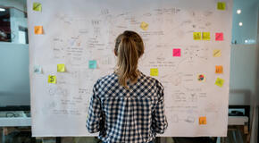 Woman sketching a business plan on a placard at a creative office