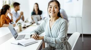 ASian woman sitting at laptop computer in business setting