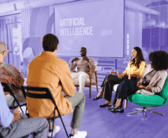 Group of people attending a panel discussion on artificial intelligence in a modern conference room.