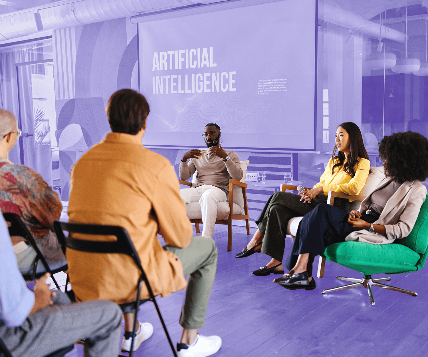 Group of people attending a panel discussion on artificial intelligence in a modern conference room.