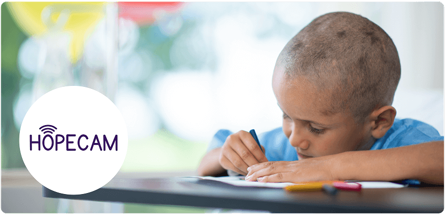 Young child coloring with markers at a table, next to the Hopecam logo.