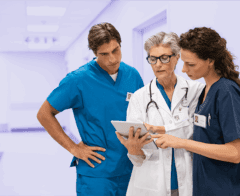 Three medical professionals reviewing their CyberGrants for Life Sciences medical grantmaking software.