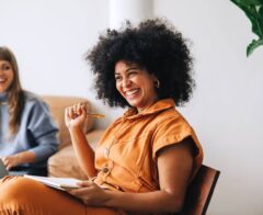 Businesswoman smiling happily while sitting in a meeting with her colleague.