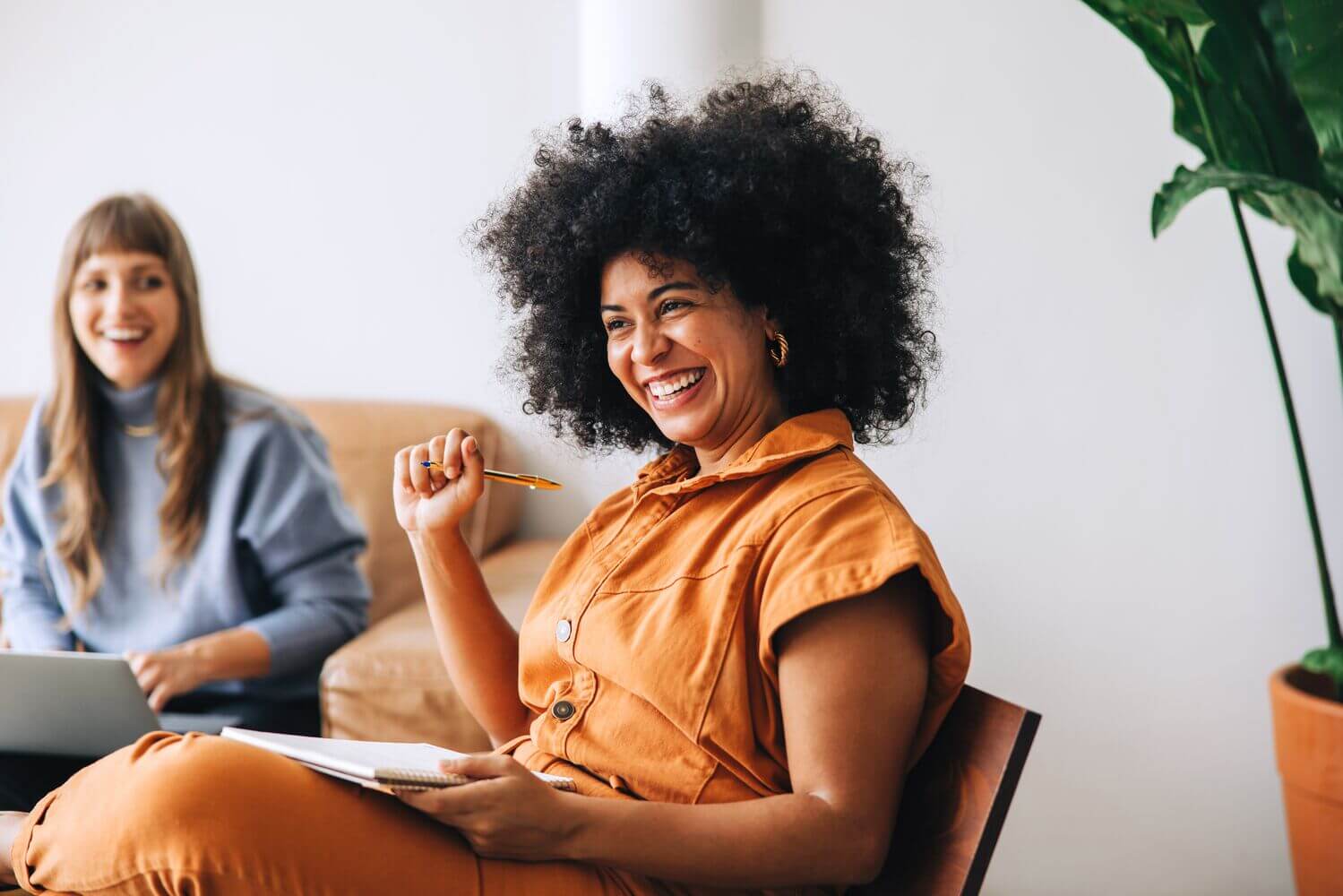 Businesswoman smiling happily while sitting in a meeting with her colleague.