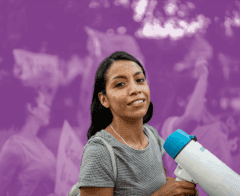 Woman holding a megaphone and smiling at a rally or protest event.