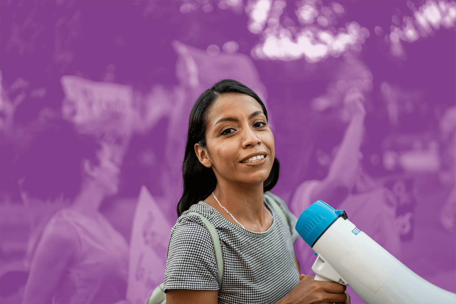 Woman holding a megaphone and smiling at a rally or protest event.