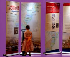 Young girl reading exhibit panels about the American Revolution.