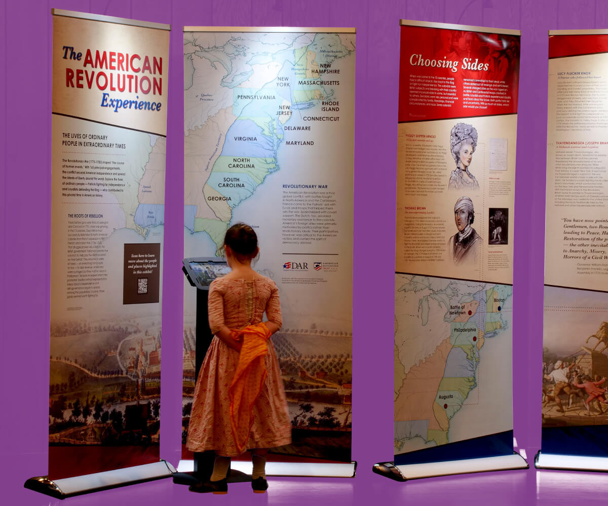 Young girl reading exhibit panels about the American Revolution.