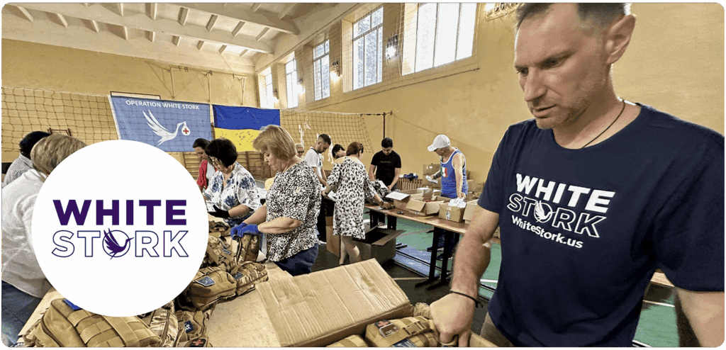 Volunteers at a White Stork facility preparing aid packages, with the White Stork logo displayed in the foreground.