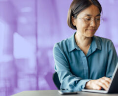 A woman working on laptops using a Givebutter alternative.
