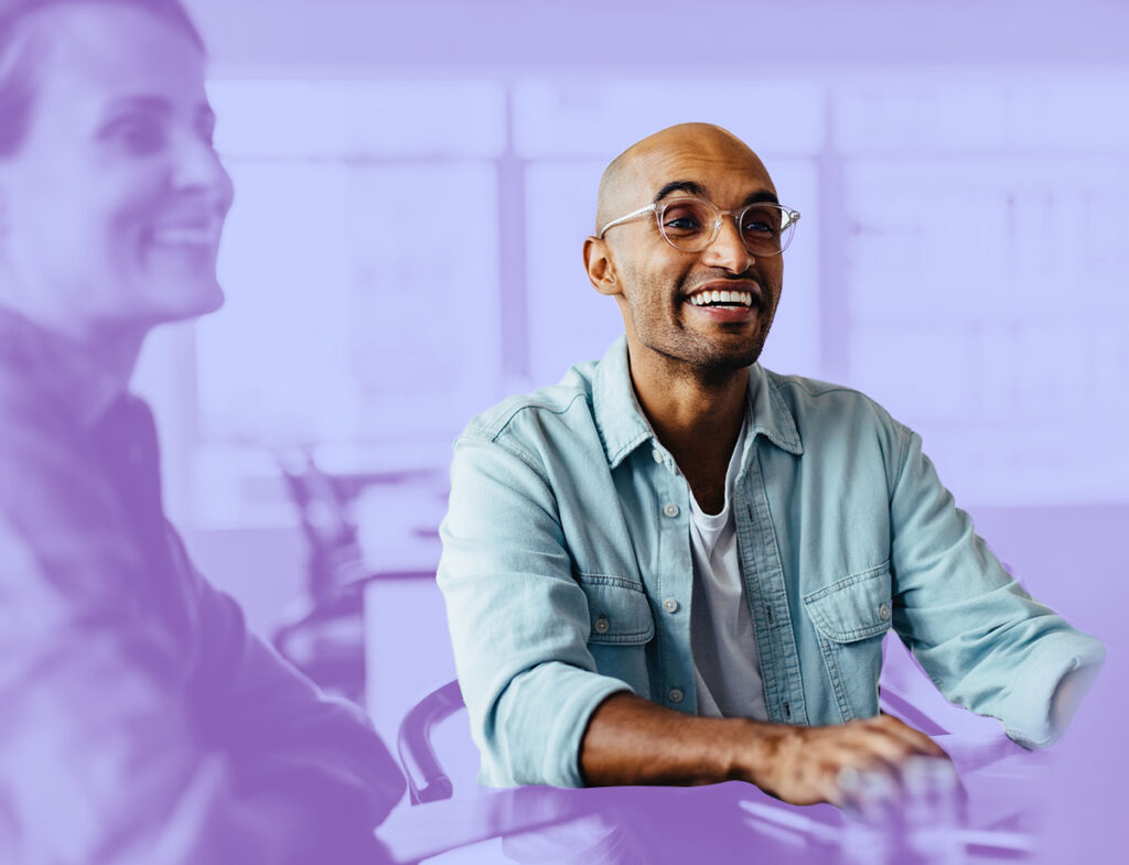 A picture of someone sitting in the office of a socially responsible company and smiling.