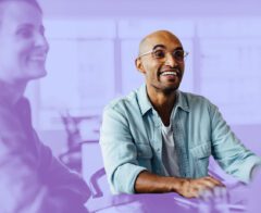 A picture of someone sitting in the office of a socially responsible company and smiling.