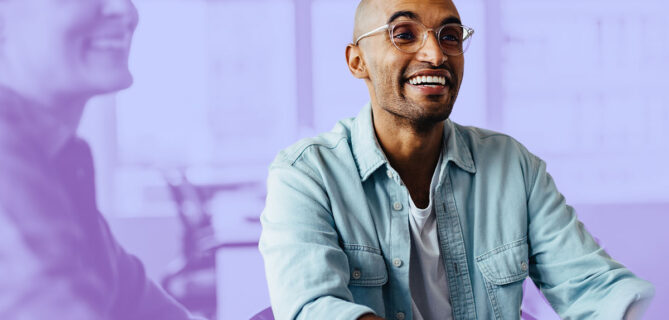 A picture of someone sitting in the office of a socially responsible company and smiling.