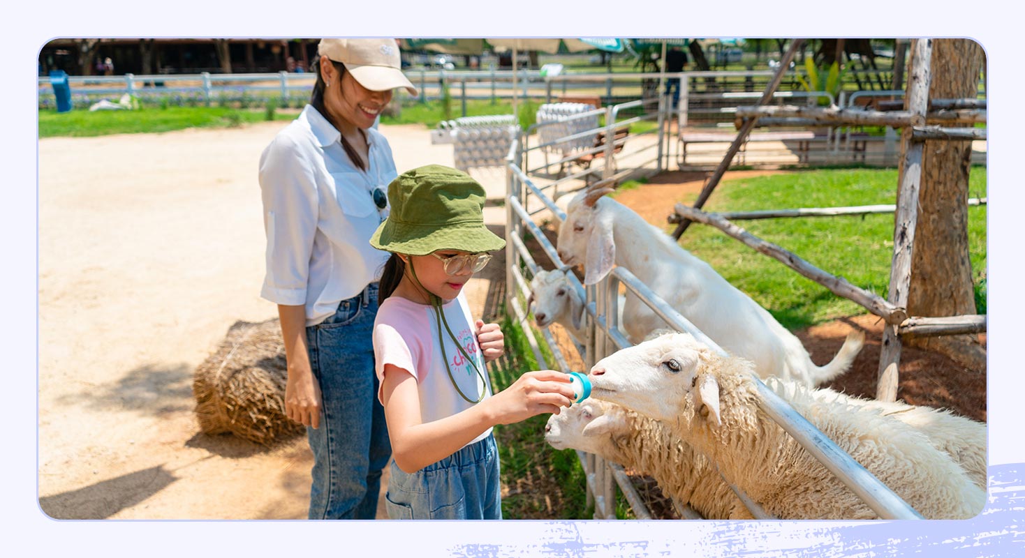 A photo of a mother and daughter at a petting zoo.