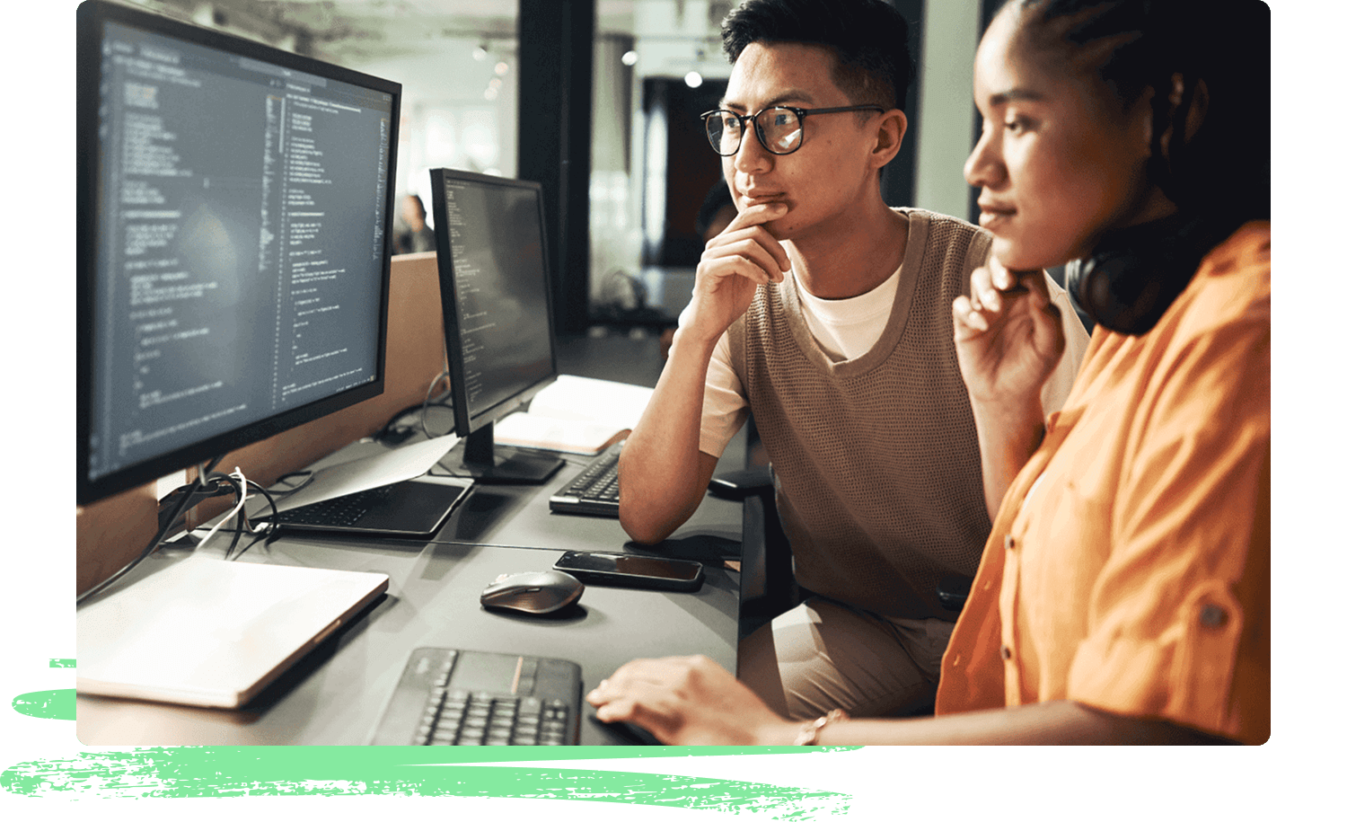 Two programmers sit side by side at a workstation, looking intently at computer screens filled with code. Their focused expressions convey the importance of security in AI systems.