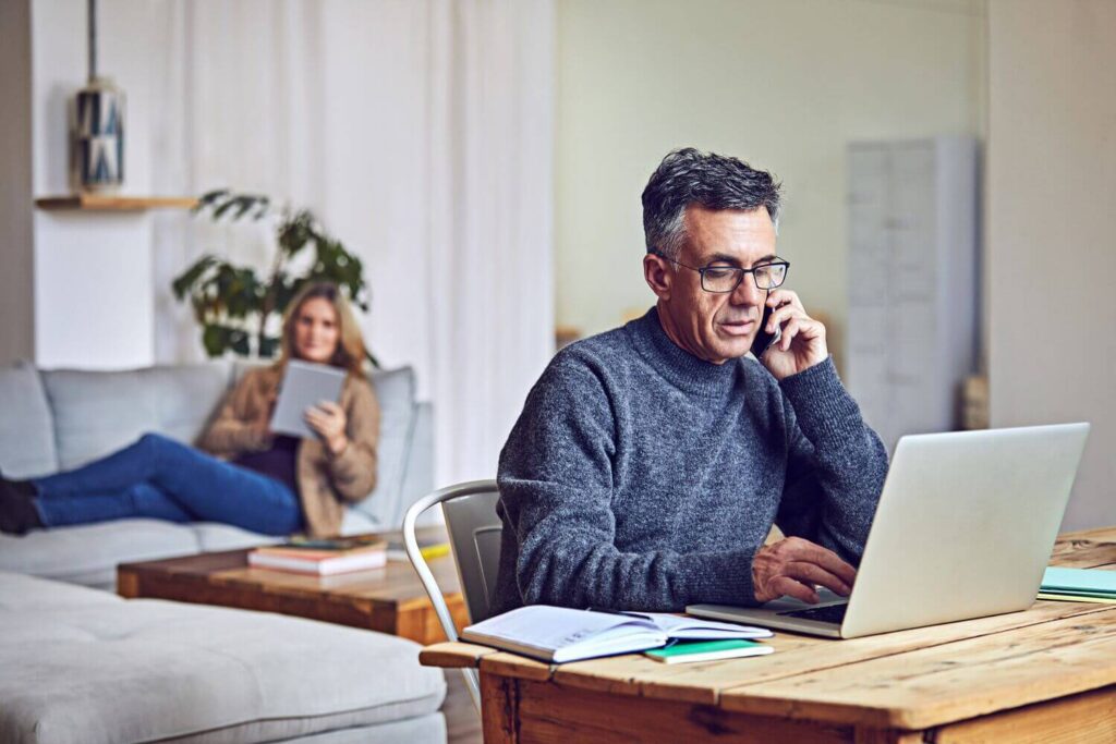 Shot of a mature couple using a laptop and tablet at home