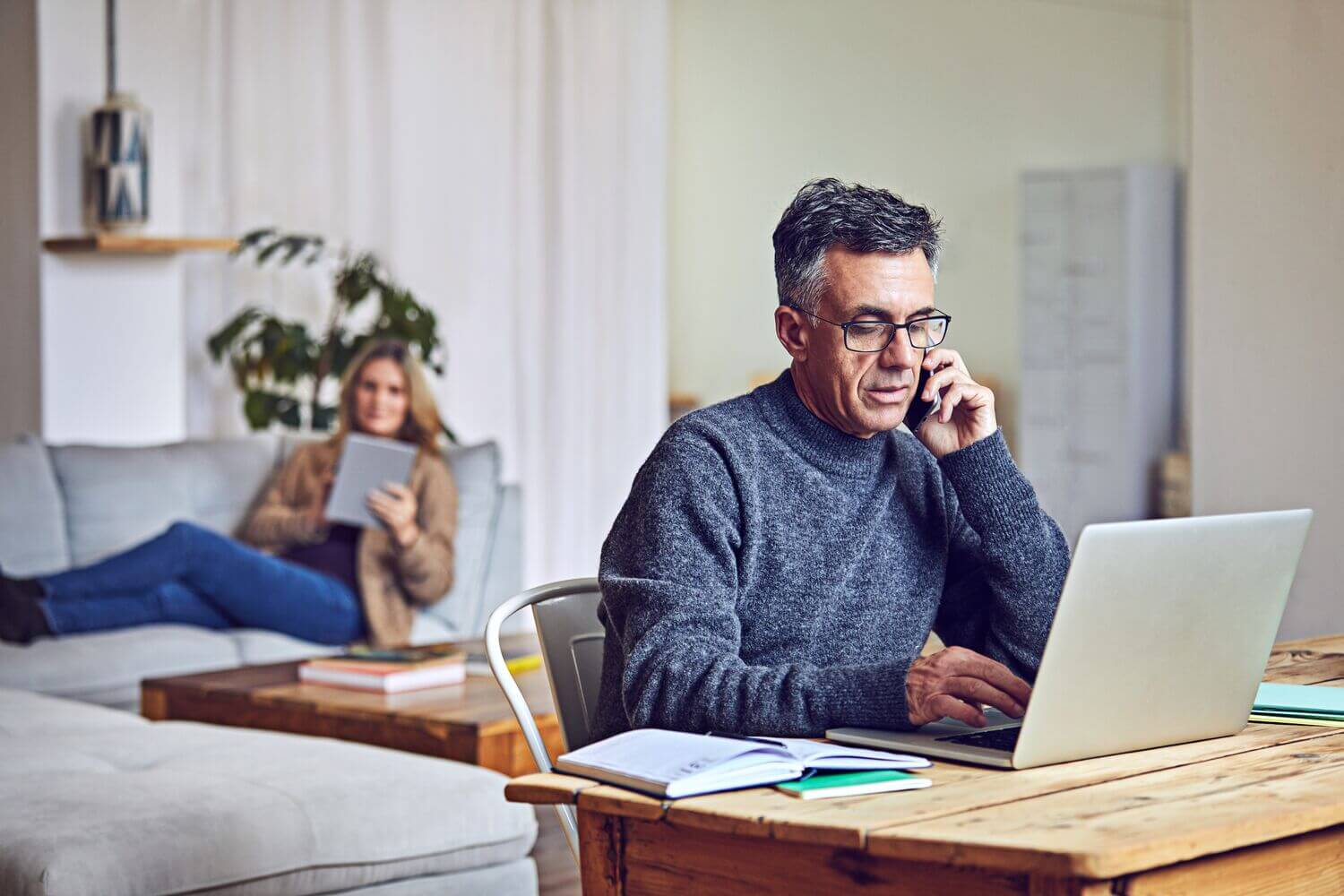 Shot of a mature couple using a laptop and tablet at home