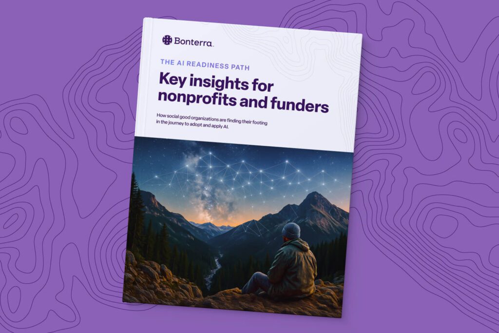 A Bonterra-branded report cover titled “The AI Readiness Path: Key insights for nonprofits and funders.” The subtitle reads, “How social good organizations are finding their footing in the journey to adopt and apply AI.” The cover image shows silhouettes of four hikers helping each other climb a rocky hill at sunset, symbolizing collaboration, support, and progress. The background features a purple topographic map design.